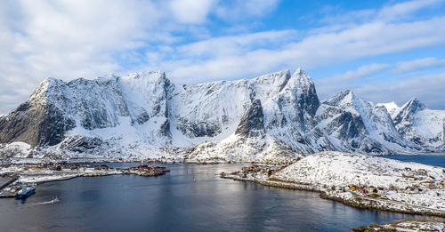 Scenic view of snowcapped mountains by lake against sky