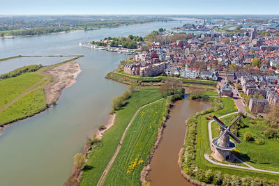 High angle view of cityscape by sea against sky