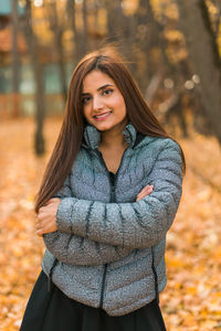 Young woman standing against trees