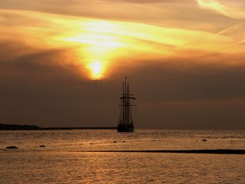 Sailboat in sea against sky during sunset