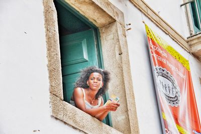 Portrait of a smiling young woman against building