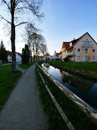 Canal amidst houses and buildings against sky