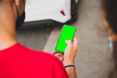 Midsection of man holding mobile phone