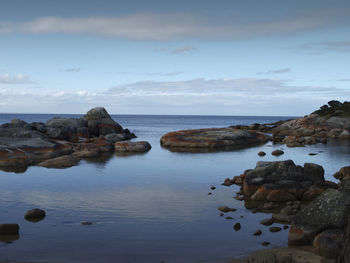 Rocks on sea shore against sky