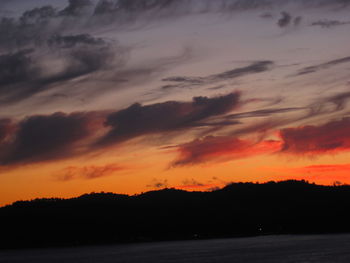 Scenic view of sea against dramatic sky during sunset