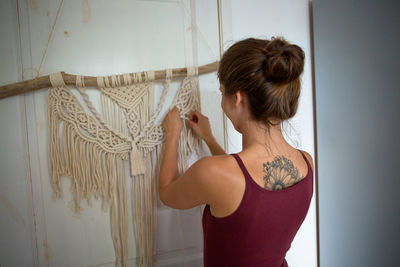 Rear view of woman standing against wall