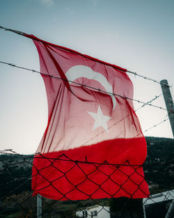 Low angle view of flags against sky