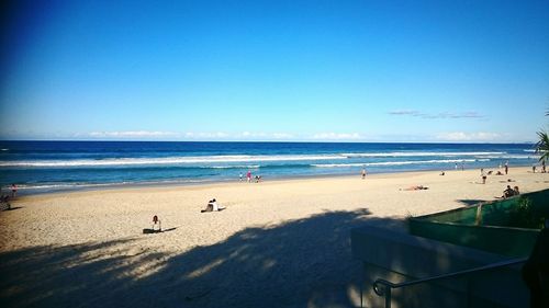 People at beach against sky