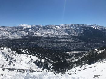 Scenic view of snowcapped mountains against clear blue sky