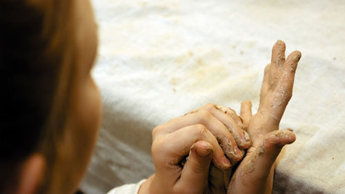 Close-up of woman hand on sand at beach