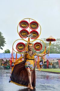 Low angle view of man holding multi colored umbrella against sky