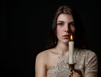 Portrait of a beautiful young woman over black background