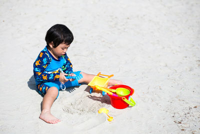 Boy playing with toys on sand