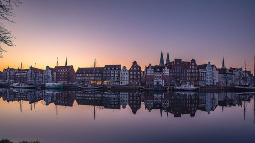 Reflection of buildings in water at sunset