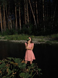 Rear view of woman standing in forest