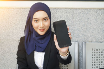 Portrait of young woman using mobile phone