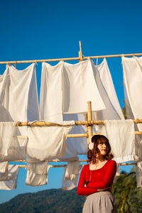 Young woman standing against clear blue sky