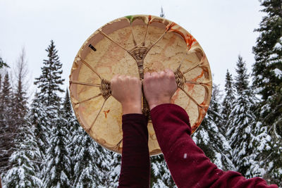 Low angle view of person holding umbrella against sky