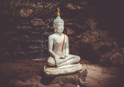 Sculpture of buddha statue against building