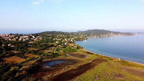 High angle view of city by sea against sky