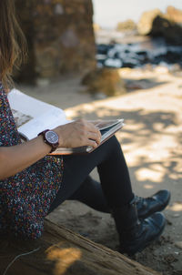 Low section of woman reading book on steps