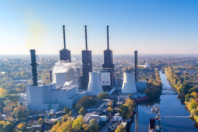 Aerial view of city against clear blue sky during sunny day