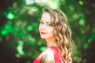 Portrait of smiling woman against trees