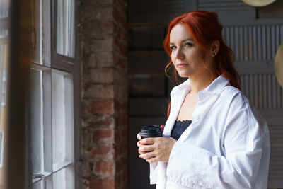 Portrait of a young woman drinking glass