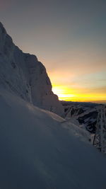 Scenic view of snow covered mountains against sky during sunset