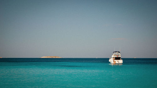 Sailboat sailing on sea against clear sky