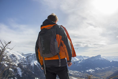Man standing on snow covered mountain against sky