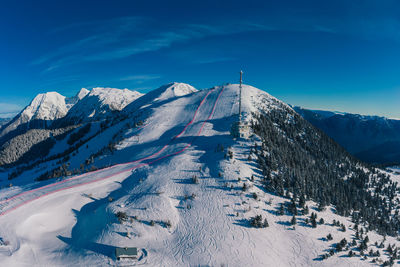 Snow covered mountain against blue sky