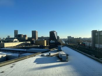 Buildings in city against clear blue sky