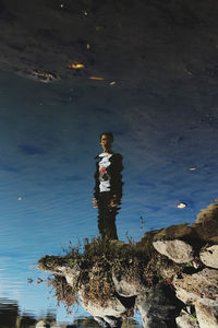 High angle view of man standing on rock at beach