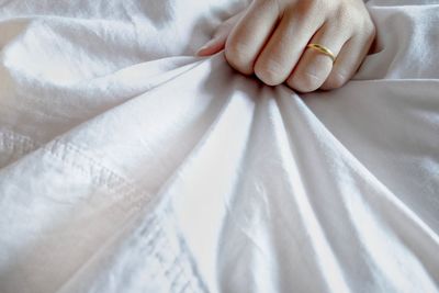 Close-up of hand holding white bed