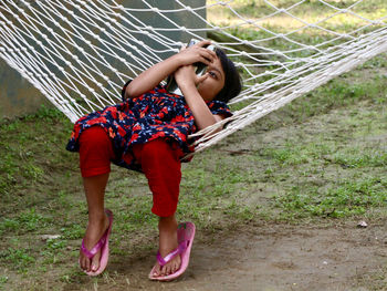 Full length of woman sitting on field