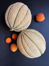 Round melons, two melons, small apricots, fresh fruits, fruits on a dark background