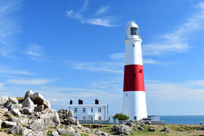 Lighthouse by sea against sky