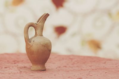 Close-up of old earthen pot on table