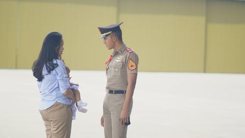 Rear view of couple standing against wall