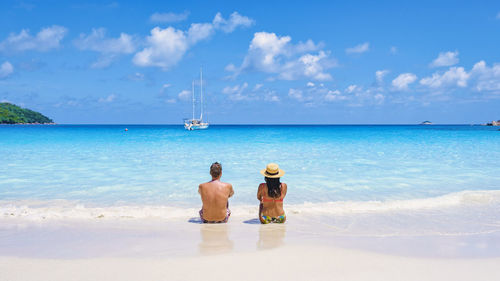 Rear view of couple in sea against sky