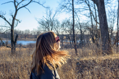 Rear view of woman standing on snow covered field