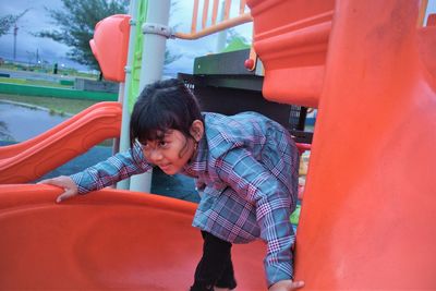 Rear view of boy on slide at playground