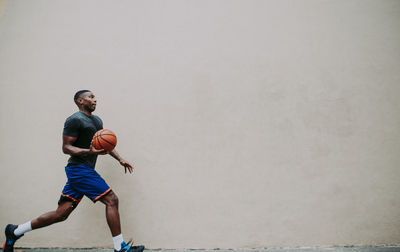 Full length of young man running on wall