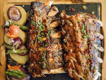 Top view of tasty grilled pork ribs with maple syrup , roasted potatoes and vegetables