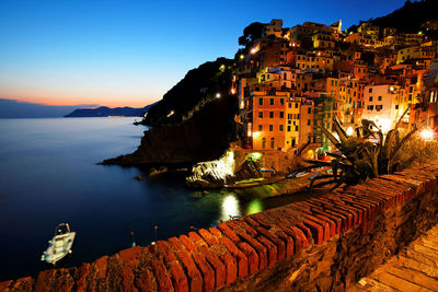 Buildings by sea at cinque terre during dusk