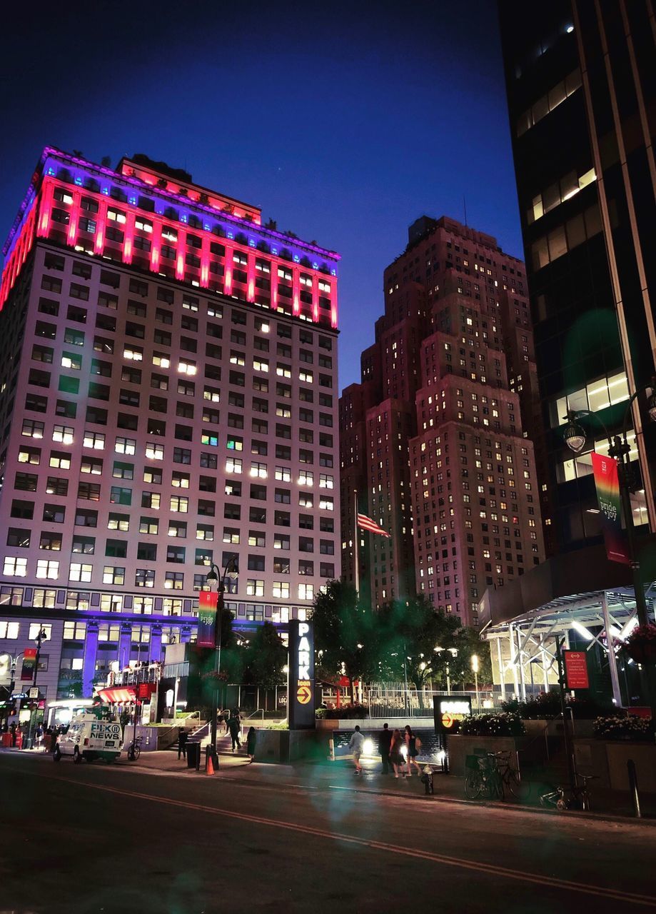 ILLUMINATED CITY STREET AND BUILDINGS AT NIGHT