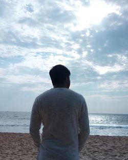 Rear view of a man standing on beach