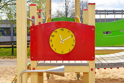 Close-up of clock on yellow wall