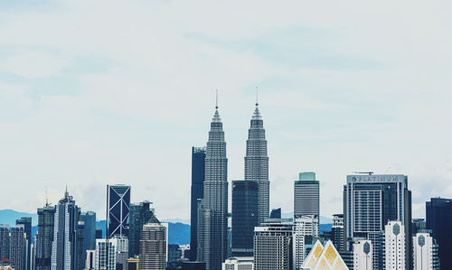 Buildings in city against cloudy sky